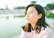 Close-up portrait of a young woman outdoors in Jakarta with serene expression.