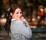 Woman in stylish autumn attire poses in a Mexico City park, showcasing urban elegance and natural charm.